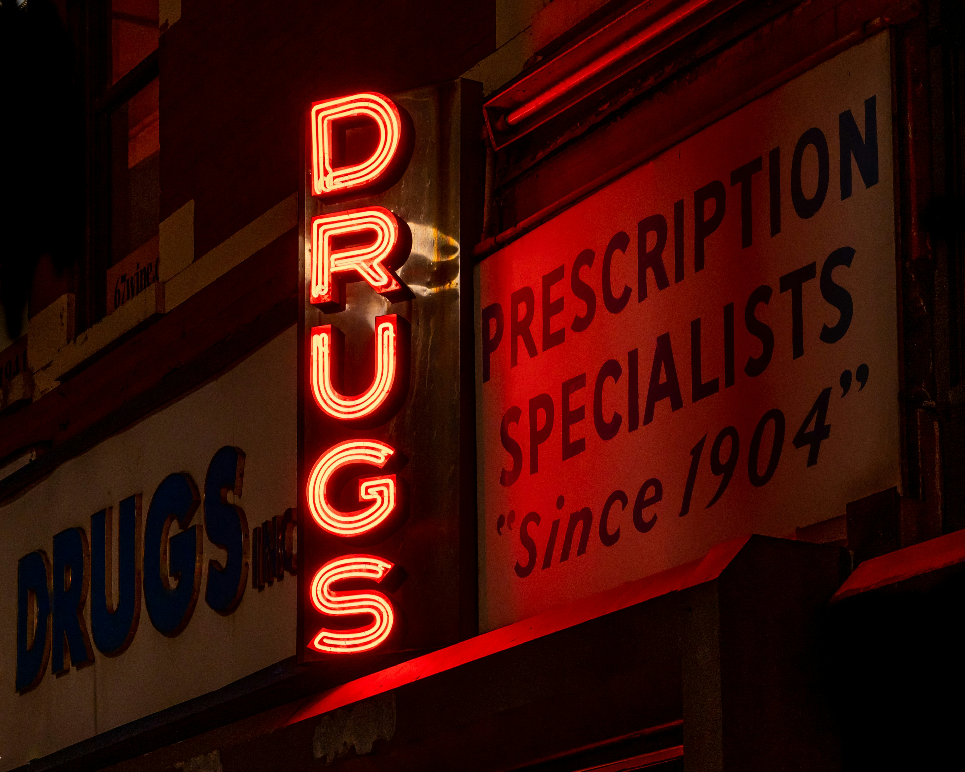 Red neon sign read drugs outside drug store